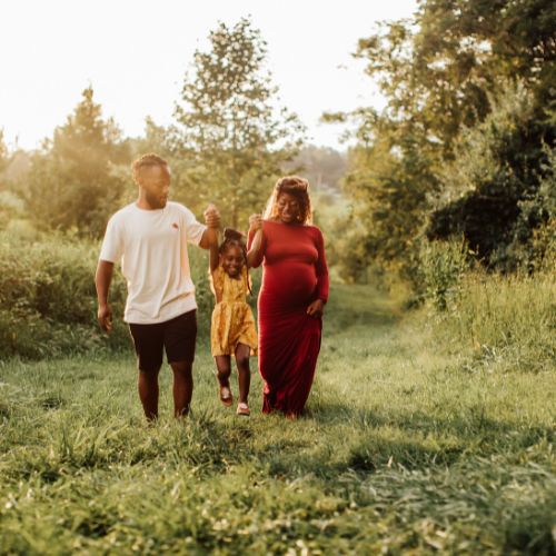 Father and mother lifting their childs hands gently