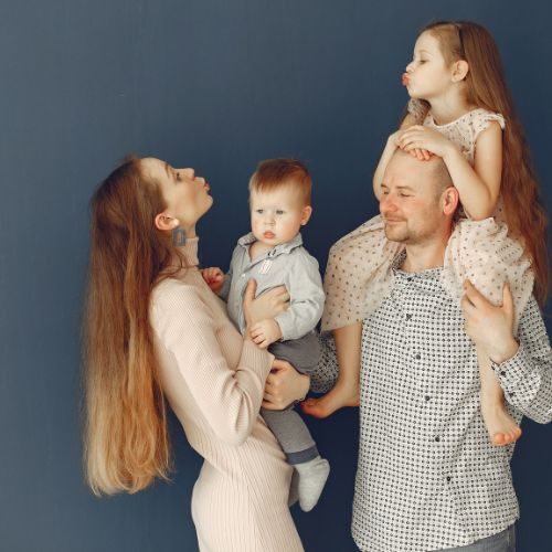 Family posing for a photo and Mother and daughter blow a kiss at each other.